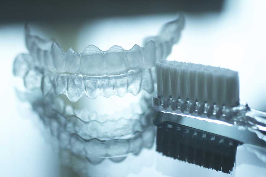 A clear retainer next to a toothbrush