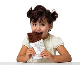Young girl eating chocolate.